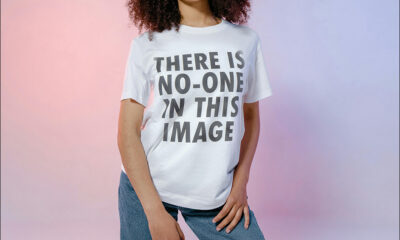 A woman wearing a t-short saying 'THERE IS NO-ONE IN THIS IMAGE', head cropped off. Based on https://www.pexels.com/photo/woman-wearing-a-white-crew-neck-t-shirt-and-denim-pants-8217313/ (Liberal CC license), + Qwen Image Edit, Adobe Firefly V3, and others.