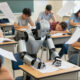 AI-generated image, by Z-Image Turbo (V1) via Krita AI Diffusion. Prompt: 'An American, hot high-school exam room in Texas,, with all the students seated exhausted in the heat, at lines of desks, trying to concentrate on winning their exams. In the center of the picture we focus on an industrial humanoid robot who is filling out the exam papers so quickly that the A$ sheets are flying around its desk in a flurry of activity. Some of the nearby, sweating and exhausted young students are looking at the tireless robot with annoyance and/or jealousy.'