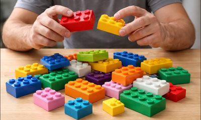 AI 生成的图像（GPT-1.5）描绘了一名男子试图将不同的乐高积木拼在一起。