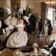 AI-generated image (GPT-2): A man sits at breakfast while a group of identical domestic robots shave him, cut his hair, prepare his food, and clean the house around him, turning even the smallest daily tasks into outsourced labor.