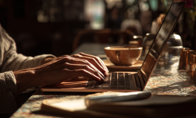 Closeup of a writer's hands typing on a laptop.