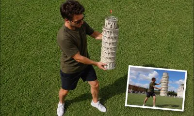 AI-generated image (GPT-2 + Photoshop): High-angle view of a man holding a scale model of the Leaning Tower of Pisa on a grassy field, with an inset photograph showing the same model aligned from ground level to resemble the full-sized tower in the background.