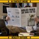 AI-generated image (GPT-2): a man in a lab coat sits in a cluttered office with his feet on a desk, reading a printed journal that obscures his face, showing a cover titled ‘BOILED FROGS ARE GOOD FOR YOU’ with charts and a cartoon frog in a beaker, surrounded by books, notes, and a yellow warning-style border.