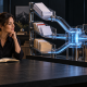 A business owner sits beside an illuminated glass system routing invoices, calendar cards and folders into organized trays.