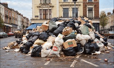 An image, outpainted laterally and colorized by GPT Image 2, but derived centrally from a real image of rubbish/trash left uncollected in the street in Camden, London, the Winter of Discontent in the UK in 1978. Source - https://www.worldhistory.org/image/21800/uncollected-trash-during-dustmens-strike-camden/
