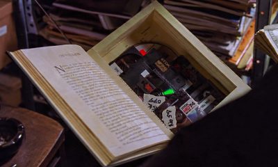 Screen capture from The Matrix (1999), featuring 'warez' on optical media, hidden inside a book, about to be sold to a willing buyer. © Warner Bros. Used for commentary and illustrative purposes.