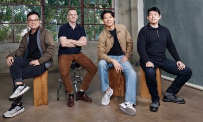Four people seated in a studio with large windows