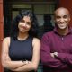 Colare co-founders Esther Thomas, left, and Nain Abdi, right, standing outside a brick building.