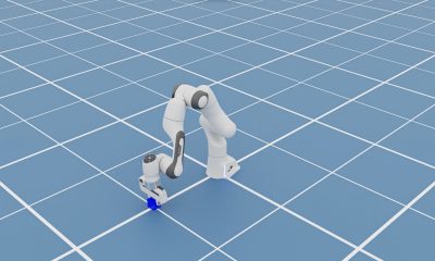 A simulated Franka robot arm reaching toward a blue block on a grid, supplied by CoreWeave.