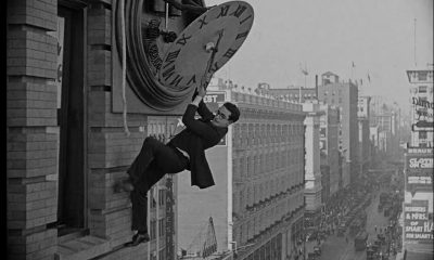 Harold Lloyd hangs from a clock face in Safety Last! (1923). The film is in the US public domain.. Source: https://www.youtube.com/watch?v=tzh4htLXp6Q