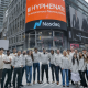 Hyphenate team in Times Square beneath the Hyphenate Nasdaq display.