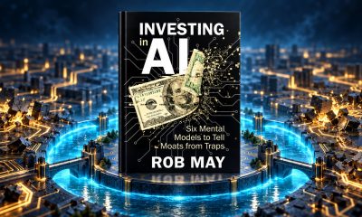 Investing in AI by Rob May standing above a glowing moat in a circuit-board landscape.