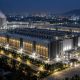 Data-centre campus at night with cooling towers and lit server halls