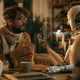 A man sitting at a table having a friendly conversation with a robot.