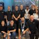Twelve members of the Salience Labs team at their optical switching exhibition booth at ECOC 2026.