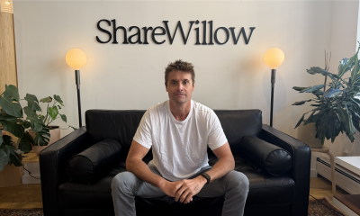 ShareWillow founder and CEO Ryan Shank seated beneath the company sign.