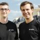 Spiko co-founders on a Paris rooftop wearing Spiko-branded shirts.